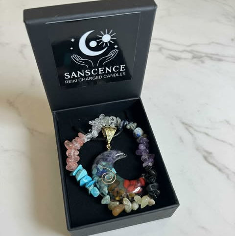Colorful beaded bracelet with a pendant in a 'Sanscence' box on a white surface