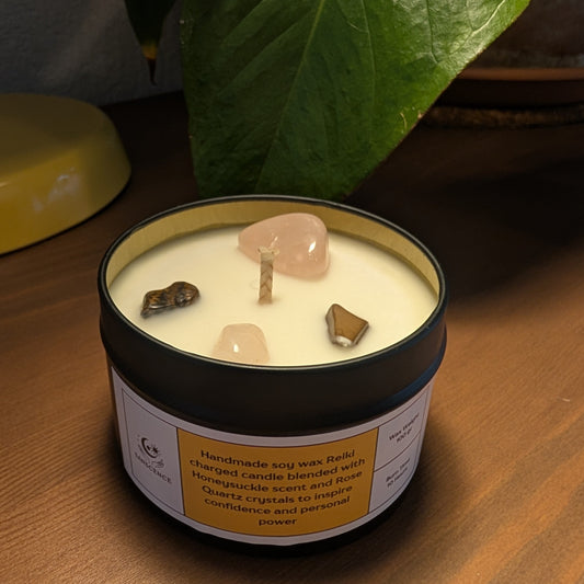 Candle in a tin with decorative stones on a wooden surface