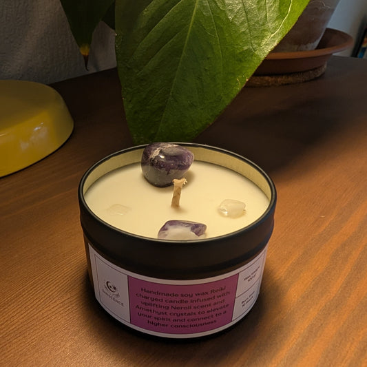 Candle in a tin with purple stones on a wooden surface