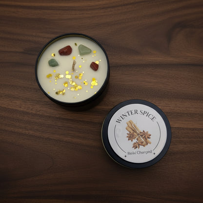 Candle with decorative stones and glitter, labeled 'Winter Spice', on a light gray background