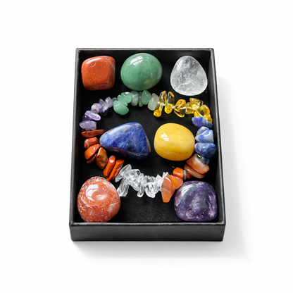 Assorted colorful crystals and gemstones in a black box on a white background