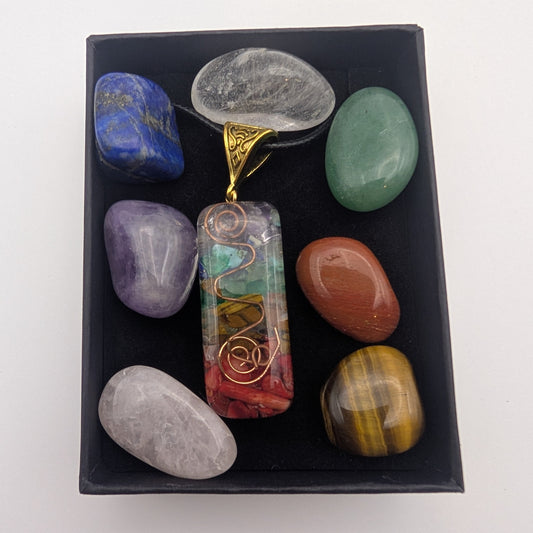 Set of colorful stones and a pendant in a black box on a white background