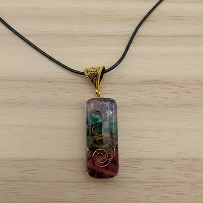 Multicolored pendant on a black cord against a light gray background