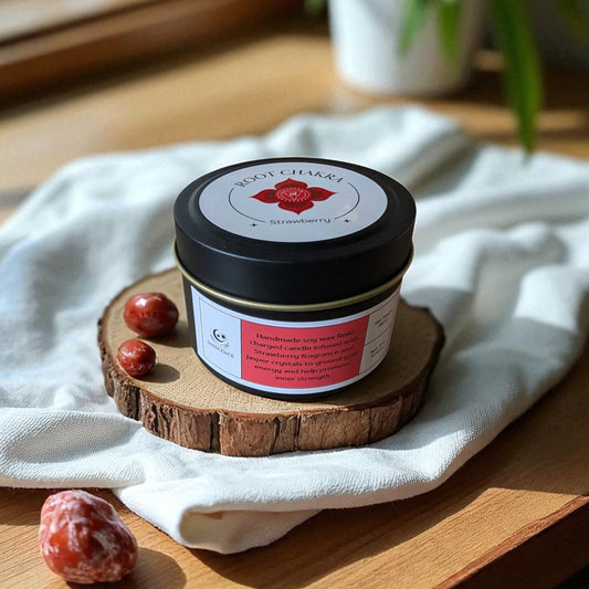 Jar of Root Chakra Candle on a wooden coaster with a white cloth and plant in the background